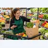 Сотрудник супермаркета собирает свежие продукты в пакет для онлайн-заказа